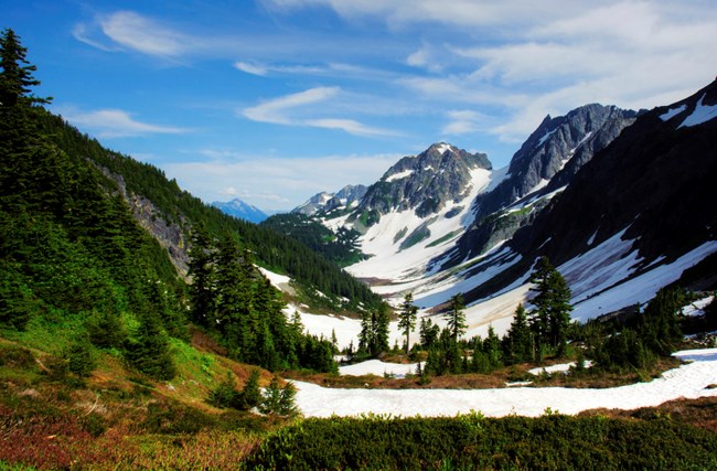 Oregon's cascade basin with a light covering of snow with blue skies and evergreens