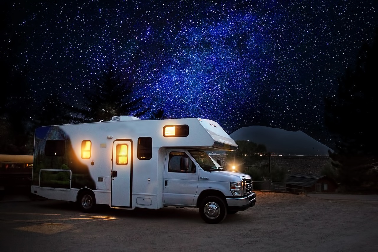 R.V campsite under a dark blue star-filled night sky